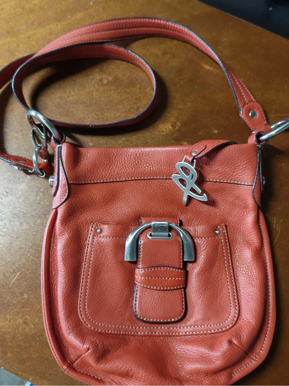 B. Makowsky Orange Leather Crossbody Bag with Silver Logo Charm